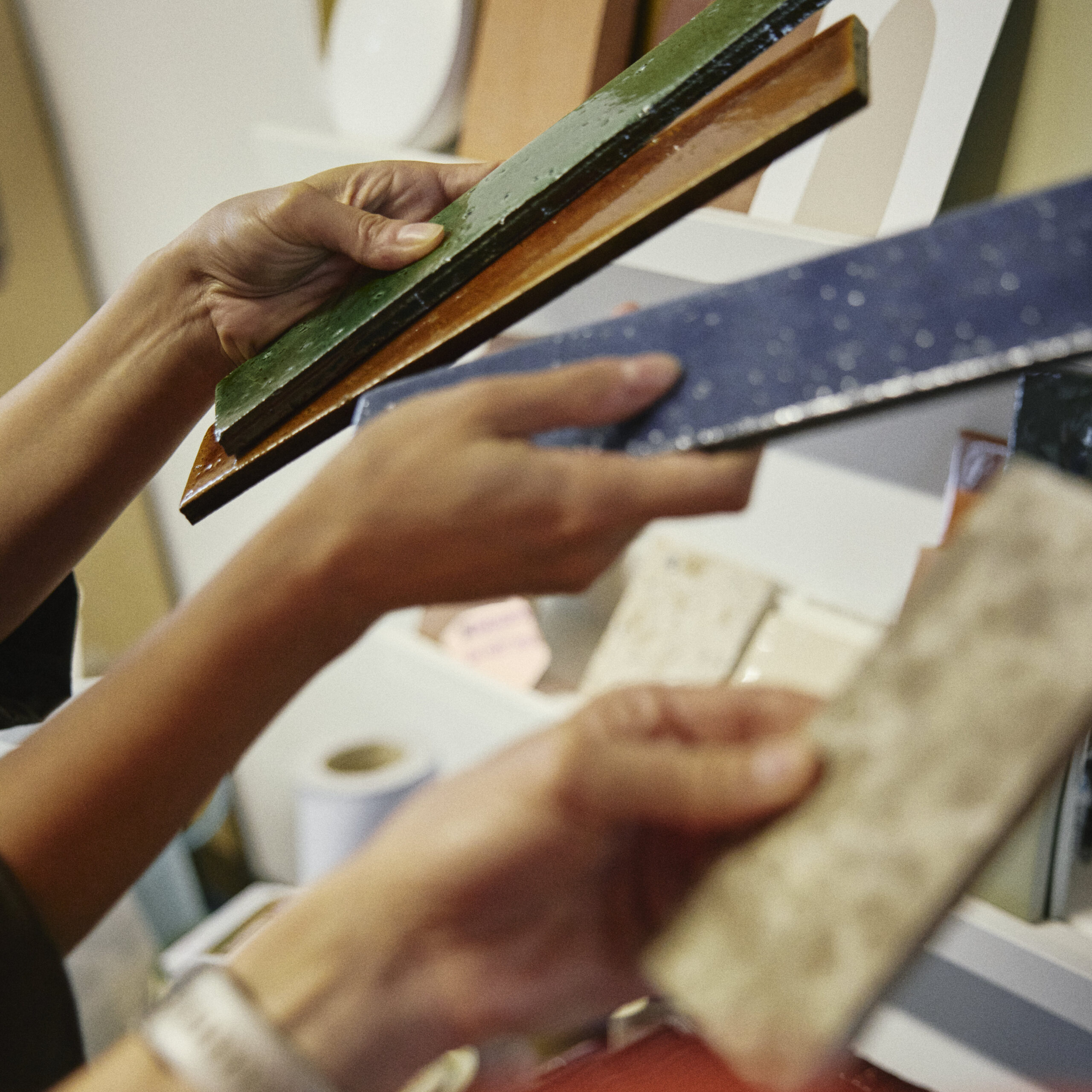 Two pairs of hands handling samples for a building project