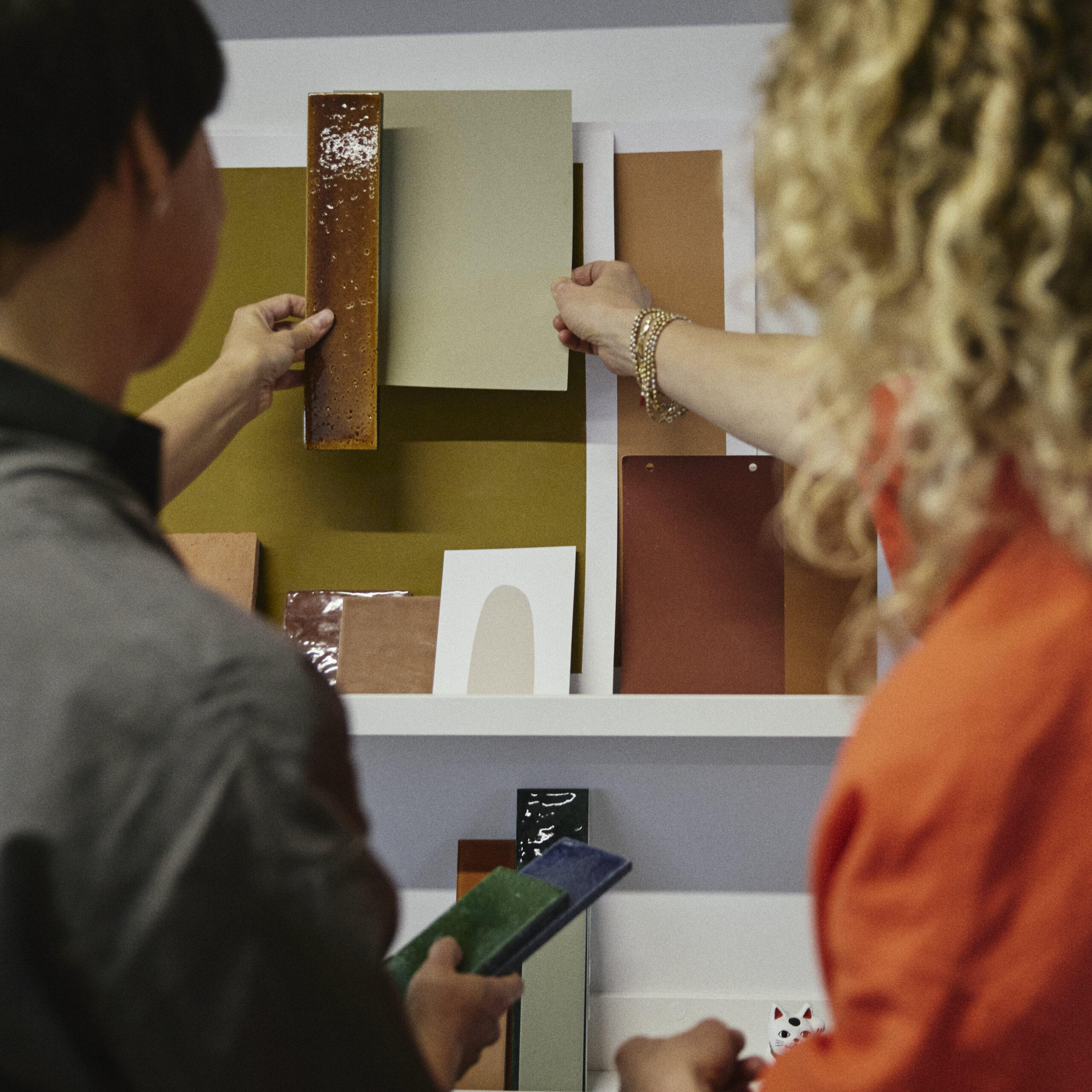 Two women consider material and colour samples in an architects office