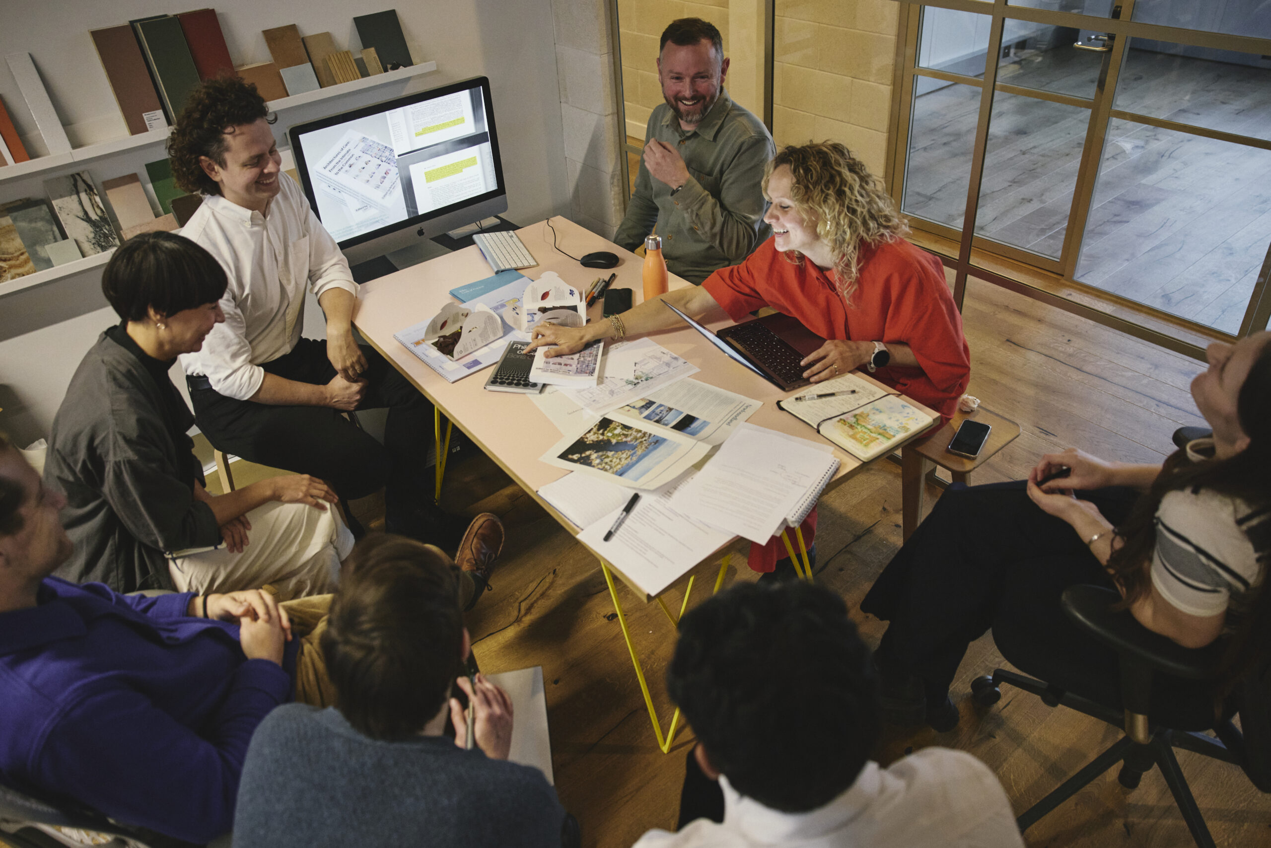 Architects sit around a table having a creative meeting