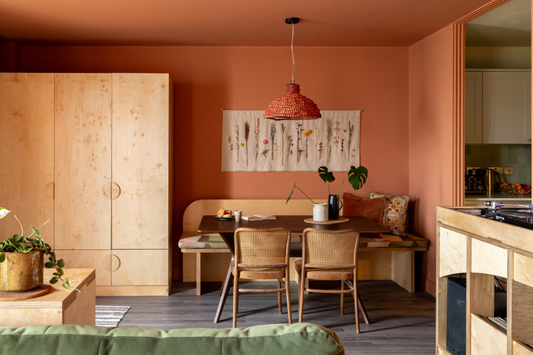 A warm and comfortable living space richly decorated in terracotta, with plywood and vintage furniture