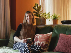 Sarah sits in her warm and welcoming living room