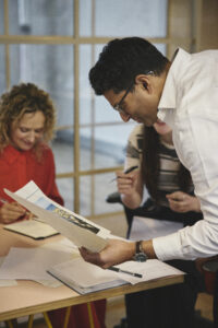 A creative meeting in a modern office. An Asian man looks at a document.
